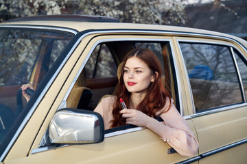 Beautiful young woman with red hair driving a car