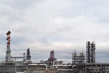 Fototapeta na wymiar general view of a chemical or oil refinery with a multitude of pipelines, factory pipes and distillation columns under a cloudy sky