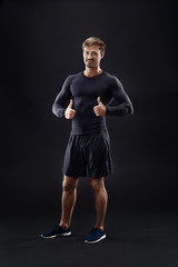 Male model in active sportswear against black background with copy space
