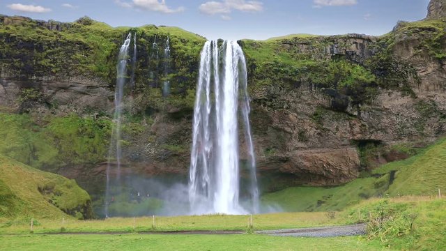 Beautiful of Seljalandsfoss waterfall with some tourist walking away, Iceland
