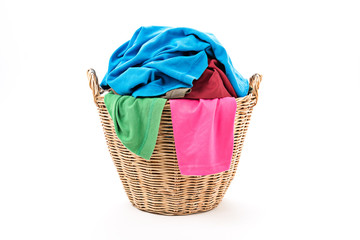 Clothes in a laundry wooden basket isolated on white background