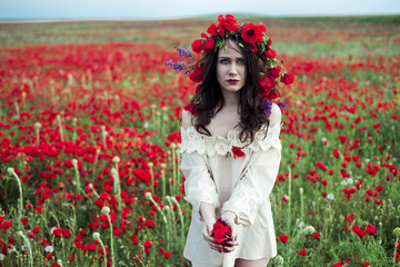 The girl poses on a poppy field