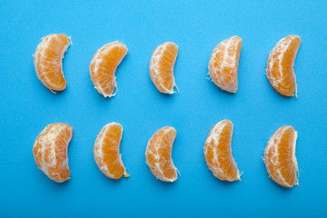 Mandarine slice isolated on blue background. Set of ripe mandarine slice.