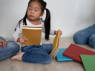 Asian Schoolgirl holding book at home for ready to go to school.Back to school concept.