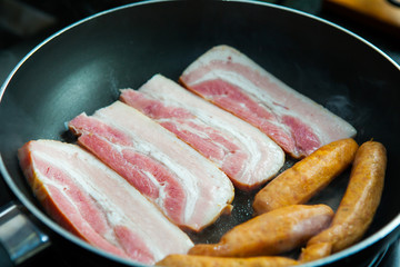 fried pork and sausage cooking in the pan