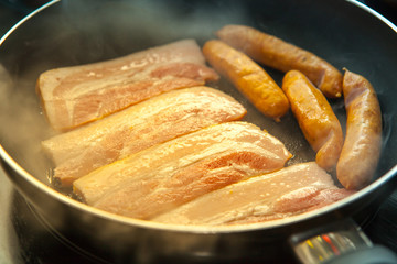 fried pork and sausage cooking in the pan morning light