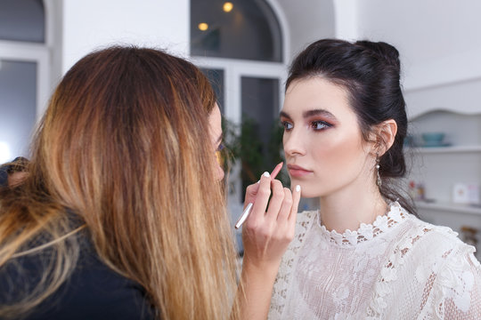 makeup artist applying lip contour with pencil