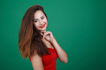 Young beautiful girl in red dress isolated green background.