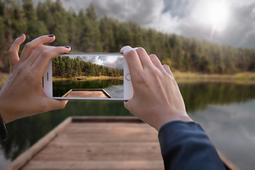 First person perspective of world traveler hands documenting trip on smartphone 