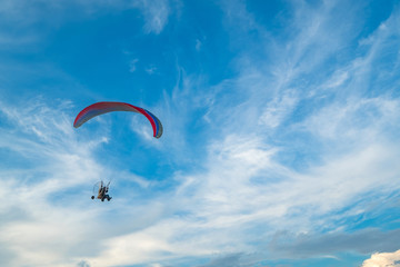 A flying paramotor on a vibrant sky with cloud. Extreme sport.