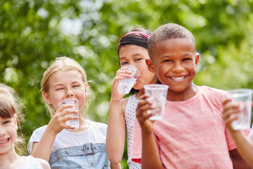  Kinder mit Plastikbechern trinkt Wasser