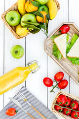 Healthy food for picnic. Sanwiches, fruits, vegetables, juice on tablecloth on white wooden background top view © 9dreamstudio
