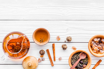 Tea ceremony concept. Tea pot, cups, dry tea leaves, sugar on white wooden background top view copyspace