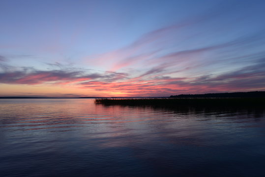 Nightfall twilight light glows in the sky above the lake