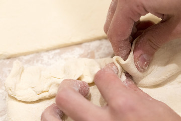 Fototapeta na wymiar Female hands making dough on kitchen background