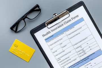 Buy health insurance. Document, bank card and calculator on dark grey background top view