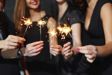 Beautiful girls in evening dresses with glasses of champagne to celebrate the New year