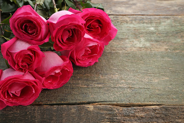 Beautiful pink roses on wooden table