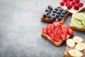 Toasts bread with berries on grey wooden table