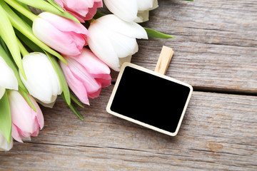 Bouquet of tulips with frame on grey wooden table