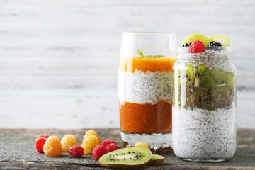 Chia pudding with berries in glass on wooden table