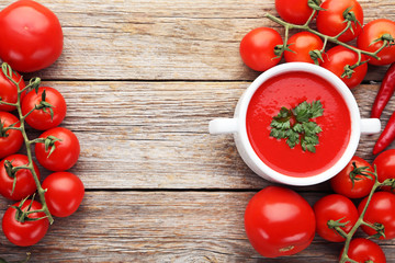 Tomato soup with parsley on grey wooden table