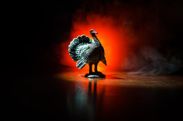 Statue of Turkey Tom strutting his stuff with red wattles and blue/white head on a smoke toned dark...