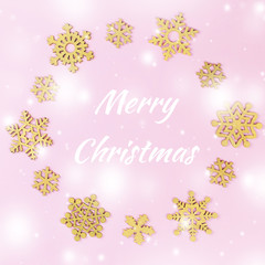 Merry Christmas card with golden snowflakes in pastel pink color
