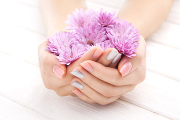 Obraz na płótnie Canvas pinc manicure with chrysanthemum flowers. spa