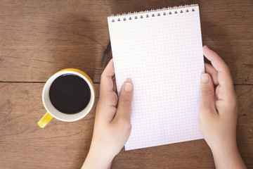Obraz premium woman hand holding a empty notebook and drinking a arabic coffee