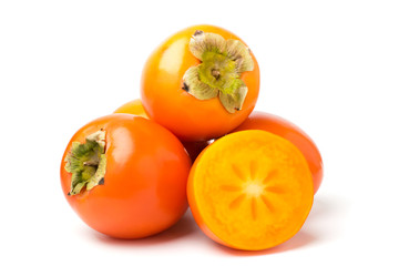A bunch of ripe persimmons on a white