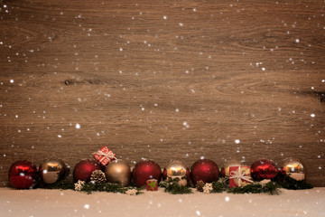 Candlight with christmas balls and fir in snow with wooden background