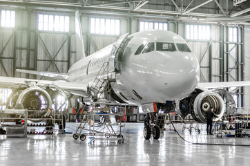 Fototapeta Passenger aircraft on maintenance of engine and fuselage repair in airport hangar. obraz