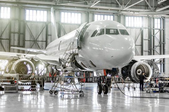 Fototapeta Passenger aircraft on maintenance of engine and fuselage repair in airport hangar.