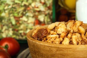 Heap of domestic salty fried pork greaves. Fatty junk food. Pork greaves on the kitchen board.