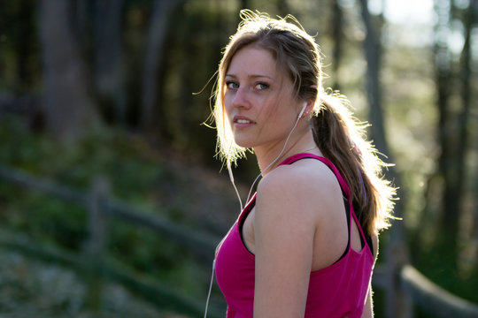 Fitness woman in nature trail looking over shoulder. Fitness lifestyle concept.