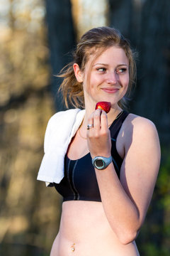 Post workout strawberry snack for attractive young woman