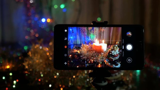 New Year's background, in the foreground, a smartphone on which a video is recorded.