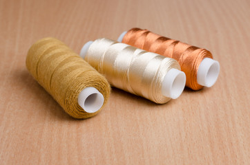 Fototapeta na wymiar Sewing thread on wooden table