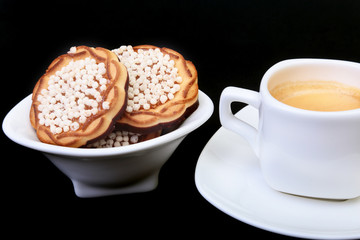 Classic espresso in white cup with homemade cake on black background. Selective focus.