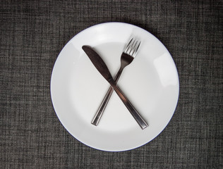 Empty dish, knife and fork on table