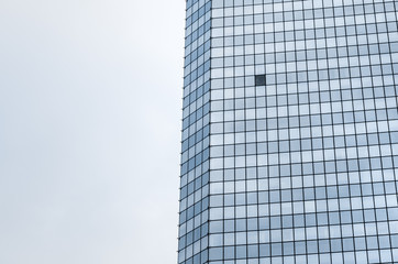 Single open window in glass window facade of corporate office skyscraper building, low angle view