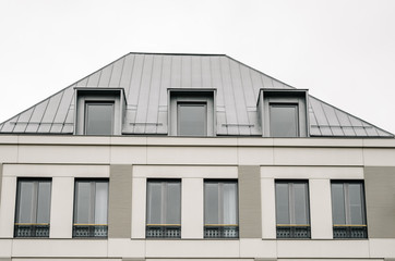 Front on new Modern house gray facade against cloudy sky, symmetry