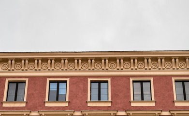Fototapeta na wymiar Ornamental facade of old history building, tenement on Old Town cloudy sky, copy space, symmetry