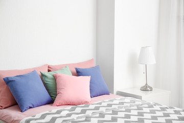 Comfortable bed with pillows in room