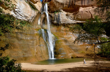 female walking near plunge pool at the bottom of Lower Calf Creek falls 
Grand Staircase - Escalante National Monument, Utah
