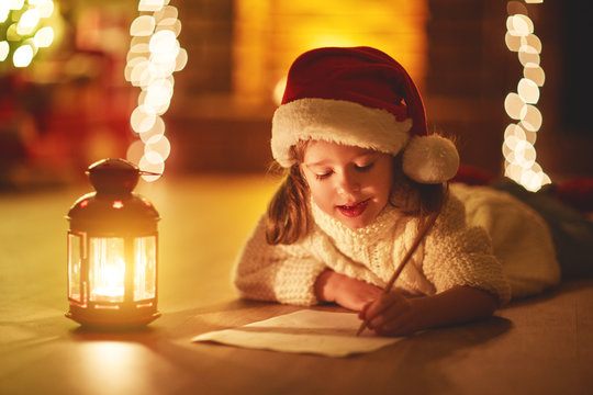 child girl writing letter santa home near Christmas tree