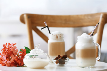 Mason jars with latte macchiato on table indoors