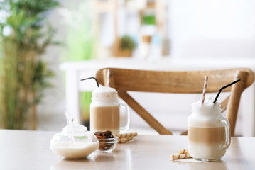 Mason jars with latte macchiato on table indoors