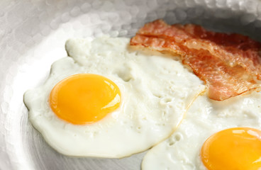 Frying pan with eggs and bacon, closeup